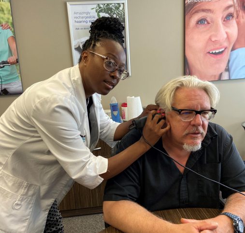 Michael Lindsay performing hearing test on a patient